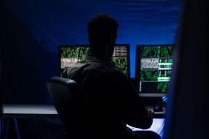 Anonymous hacker in military unifrorm on dark web, cyberwar concept.